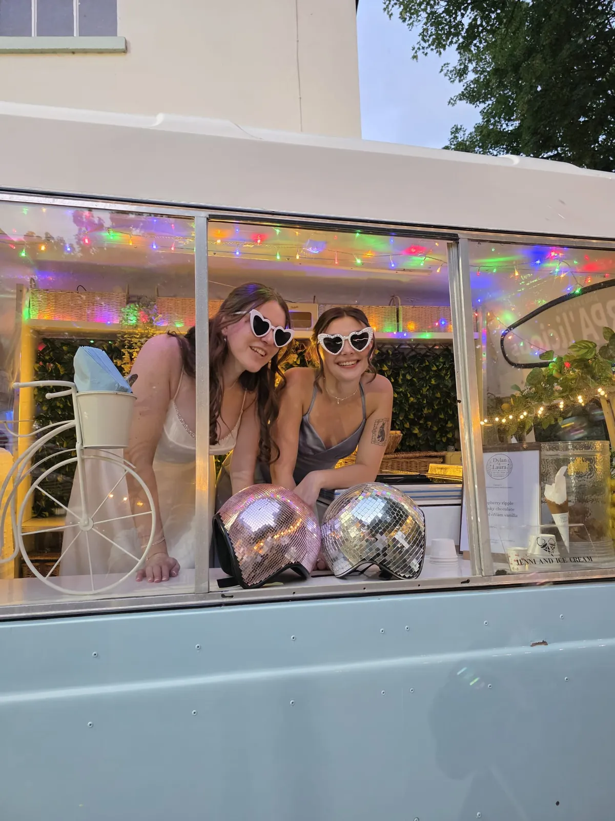 Guests trying heart-shaped glasses and playful vintage props at the Sherpa’licious window