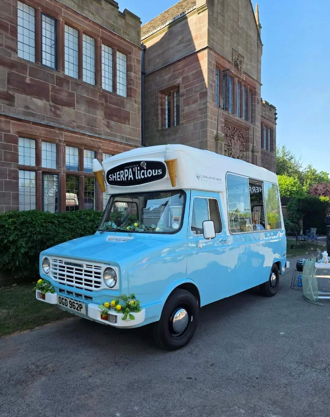 Sherpa’licious parked beside a historic country house, showing her original blue bodywork and white roof